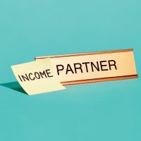 Name plate with the word "Partner" and a sticky note attached in front of the word which reads "Income"
